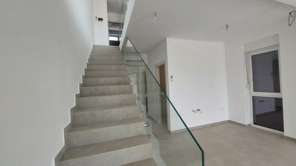 Chodba s bíle natřenými stěnami, klimatizace a dveře do dalších místností