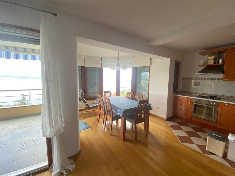 Světlá kuchyně a jídelní kout s výhledem na moře v nemovitosti v Chorvatsku.