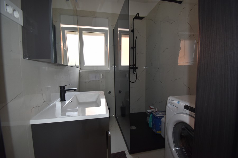 Moderní koupelna se sprchovým koutem a pračkou, součást Real Estate Croatia