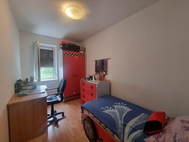 Dětský pokoj s psacím stolem a červenou šatní skříní