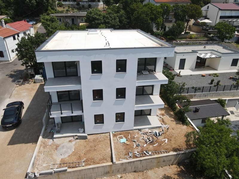 Pohled na moderní novostavby apartmánů v Chorvatsku obklopené zelení