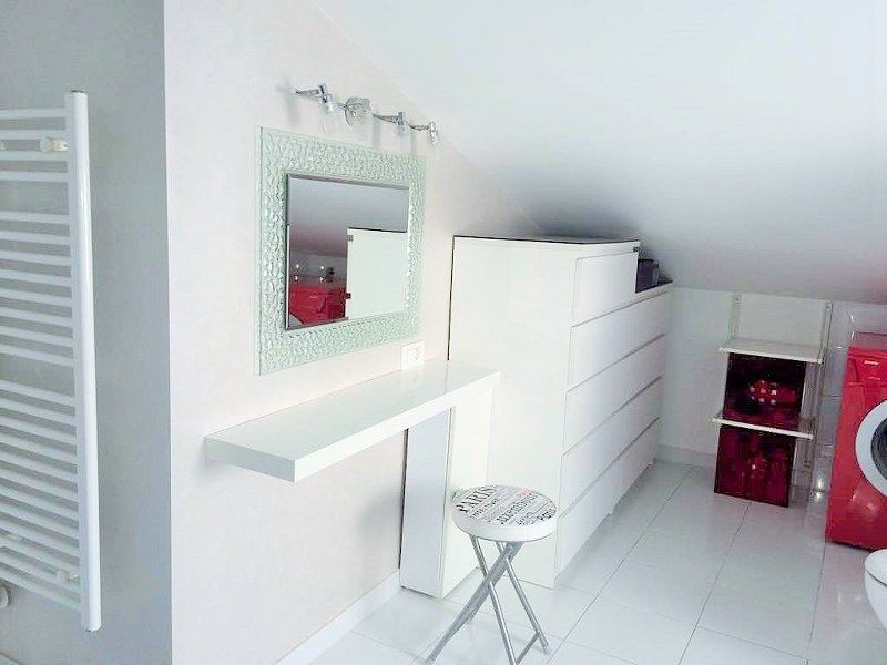 Moderní a světlý pokoj s bílým nábytkem, zrcadlem a pračkou, ideální jako šatna