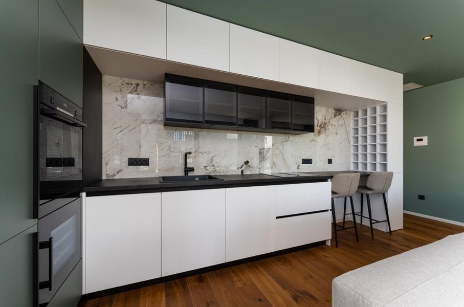 Moderní kuchyně s mramorovým pozadím, černé a bílé skříňky