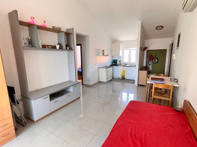 Obývací pokoj s kuchyňským koutem a klimatizací.