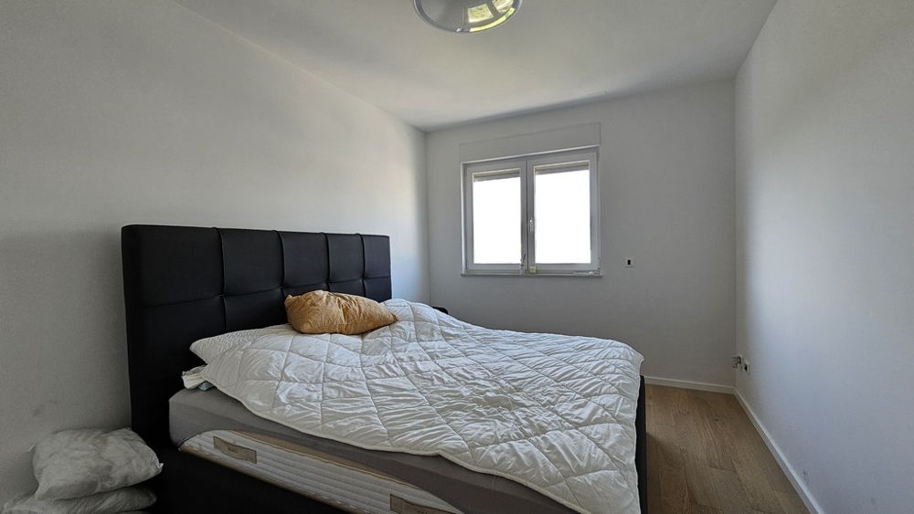 Ložnice s velkou postelí a bílou peřinou