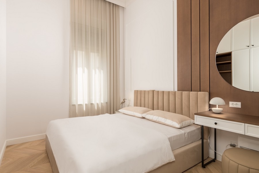 Ložnice s béžovou postelí a psacím stolem