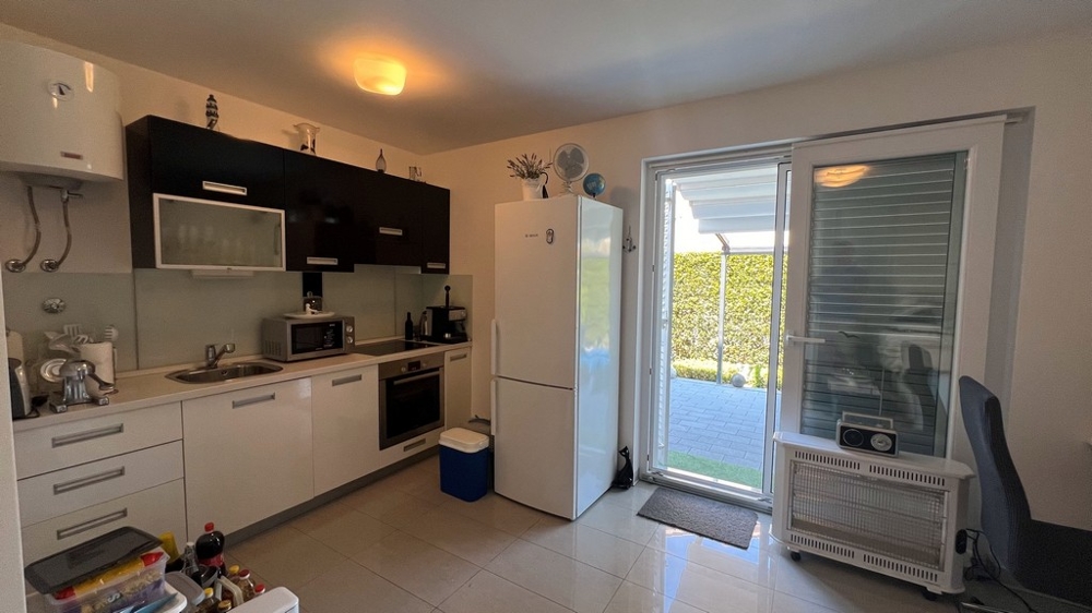 Kuchyňská část garsonky v přízemí s přímým vstupem na zahradu.