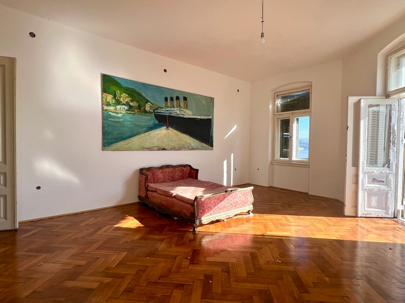 Ložnice s pravými dřevěnými podlahami a přístupem na terasu s výhledem na moře.