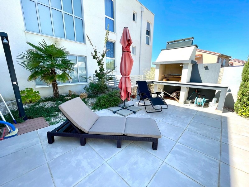 Letní kuchyně a prostor na opalování, stejně jako venkovní sprcha v soukromé venkovní části objektu.