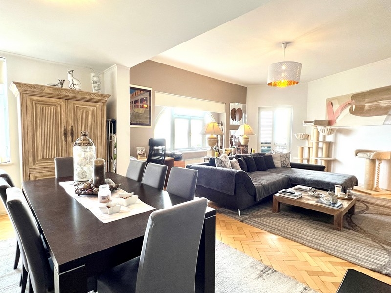 Otevřený obývací pokoj a jídelna s velkými okny a útulným osvětlením