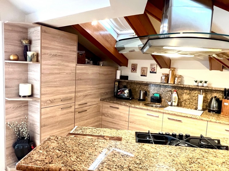Pohled do kuchyně s žulovými deskami a moderními spotřebiči