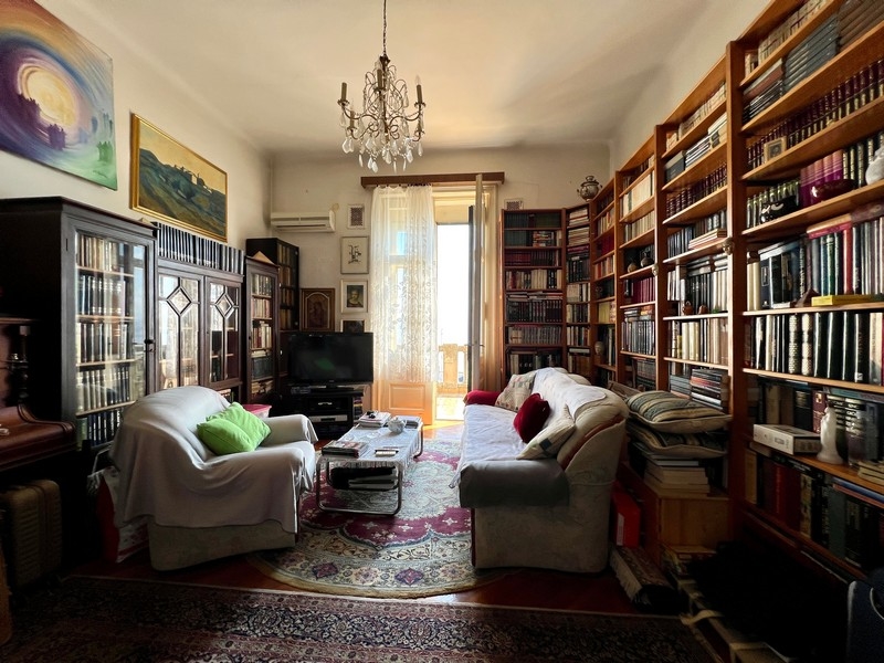 Byt s velkými a vysokými policemi na knihy.