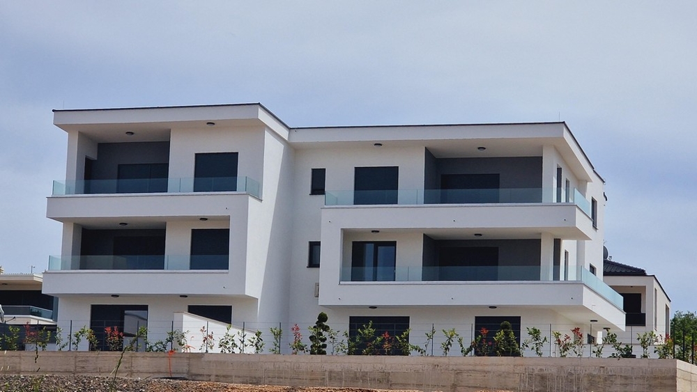 Moderní třípatrový rezidenční komplex s balkony a proskleným zábradlím