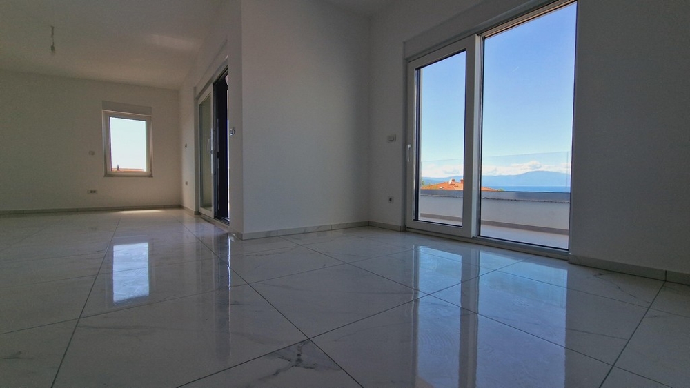 Interiér bytu s velkými okny a výhledem na moře