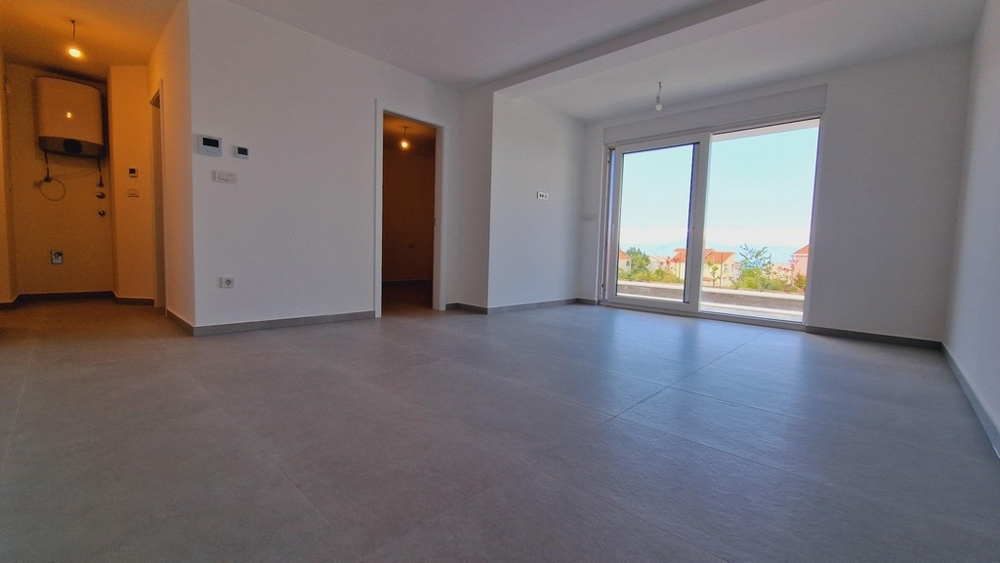 Moderní interiér bytu s velkými okny, výhledem do zahrady a vstupem do pokojů