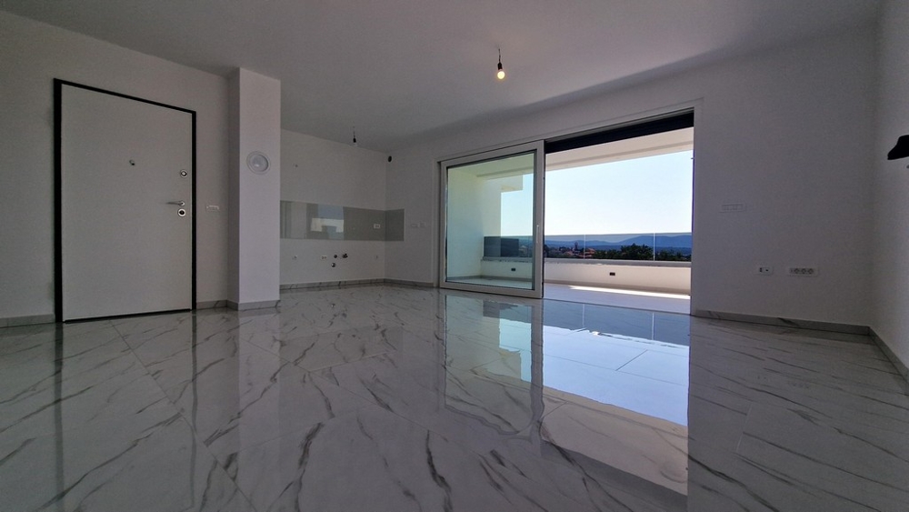 Obývací část s výhledem na terasu a moře, velké posuvné dveře.