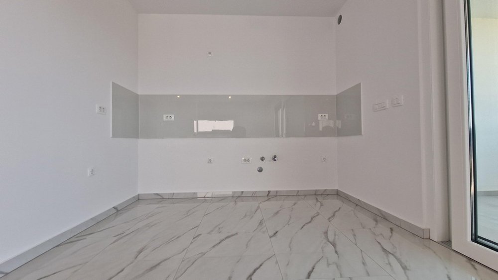 Kuchyň s možností připojení, prázdný pokoj s dlažbou.