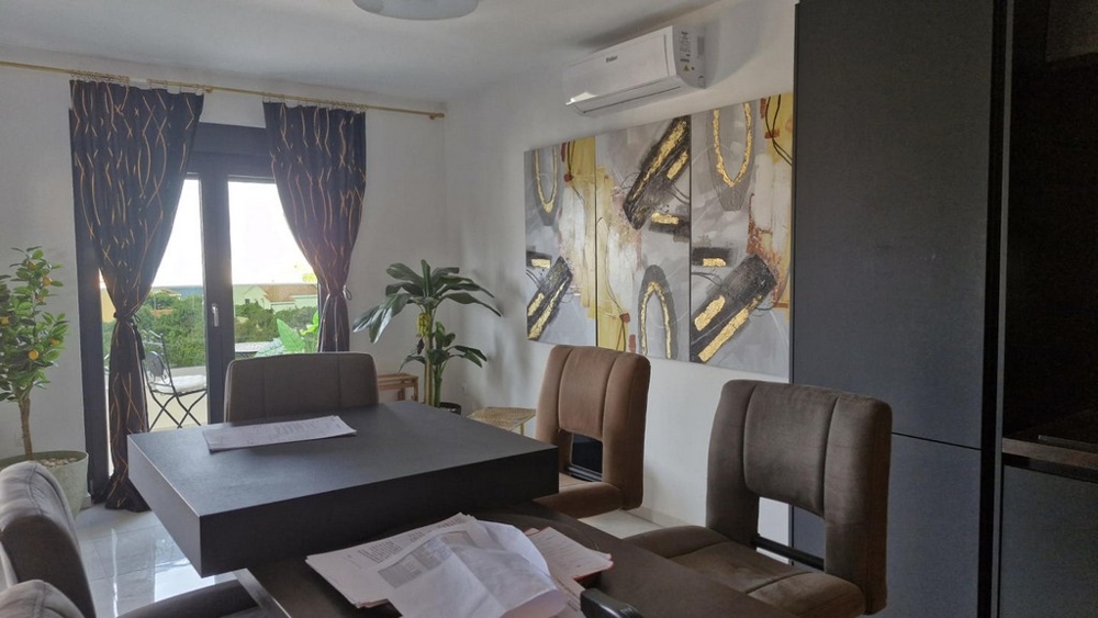 Jídelní kout se stolem, židlemi a dekoracemi, vstup na balkon