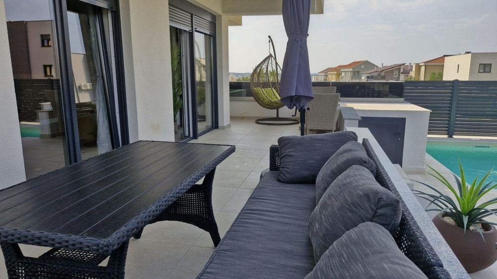 Zařízená zahrada a bazén rekreačního bytu A3413, který je na prodej v Chorvatsku v Novalji.