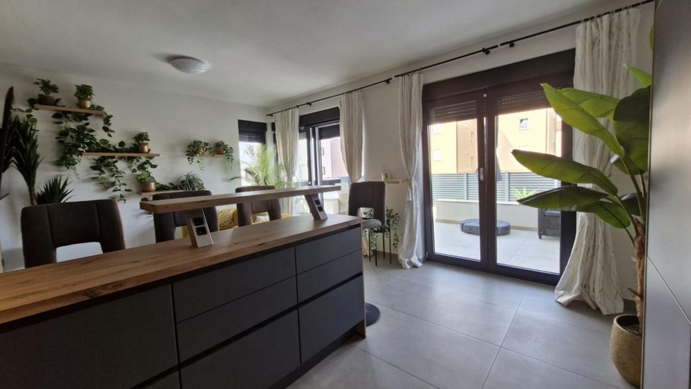 Obývací pokoj s jídelním koutem a vstupem na terasu.