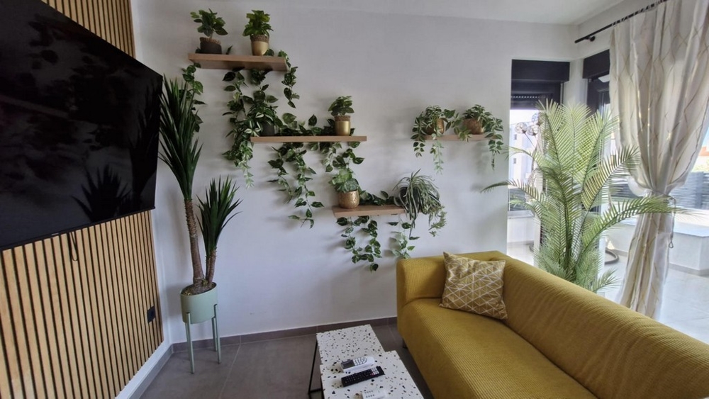 Obývací pokoj s gaučem (žlutá) a TV.