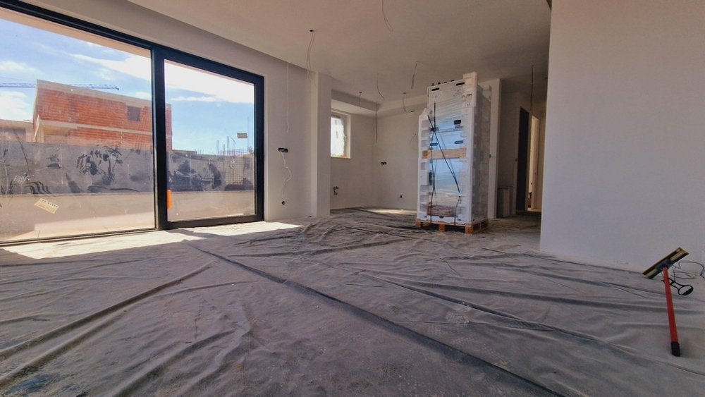 Vnitřní pohled na nový byt s velkými okny a volným výhledem na terasu a okolí.