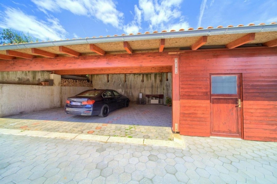 Kryté parkoviště se zaparkovaným autem a dřevěným obložením