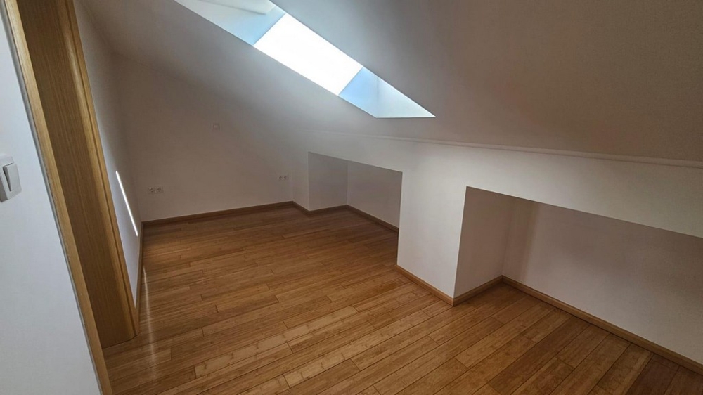 Pokoj se střešním oknem a dřevěnými podlahami