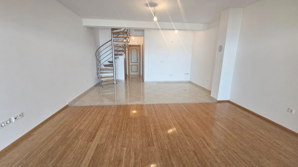 Velký obývací pokoj s točitým schodištěm a dlážděným prostorem