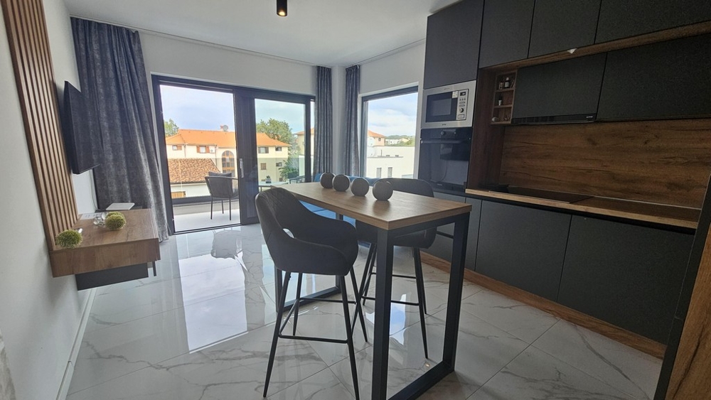 Otevřená kuchyně a jídelna s balkonem a velkým oknem