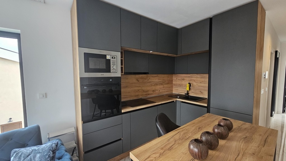 Moderní kuchyňská linka s vestavěnými spotřebiči a jídelním stolem