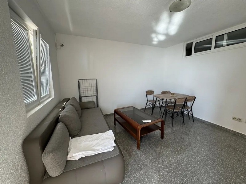 Obývací pokoj s pohovkou a jídelním stolem.