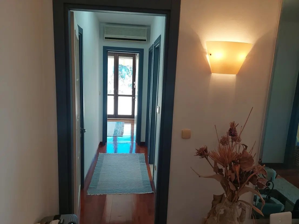 Předsíň se světlými stěnami a dřevěnými podlahami, moderně zařízený vstupní prostor