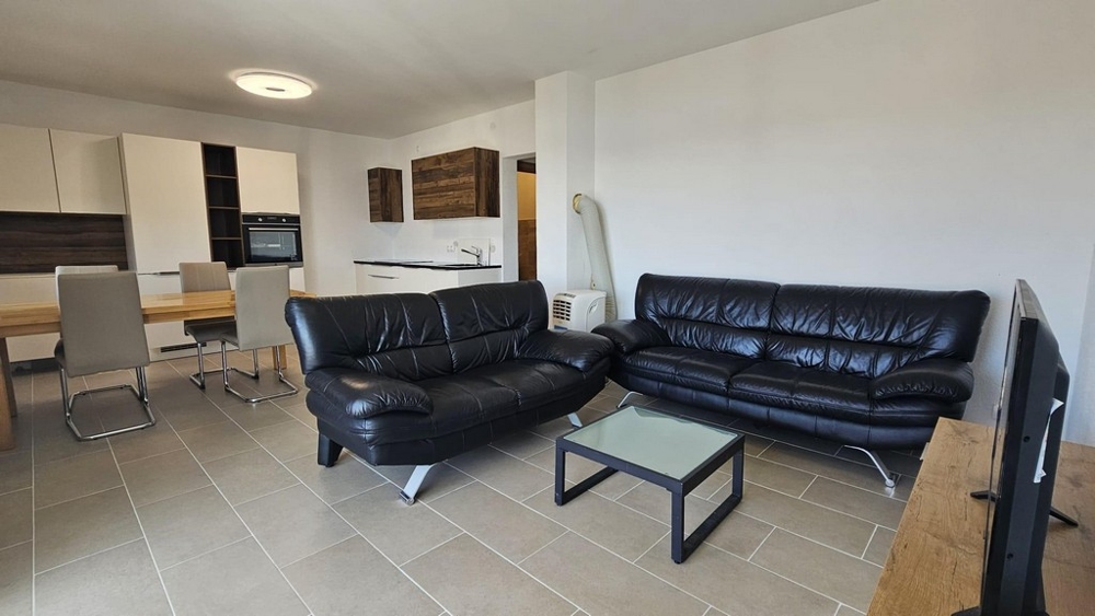 Zařízený obývací prostor a výhled do kuchyně v bytě A3475.