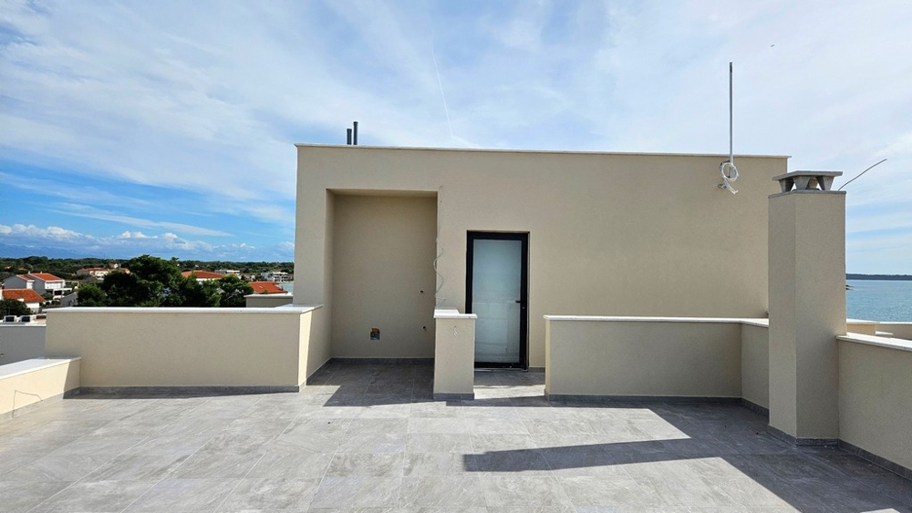 Střešní terasa s přístupovými dveřmi vedoucími do krytého prostoru