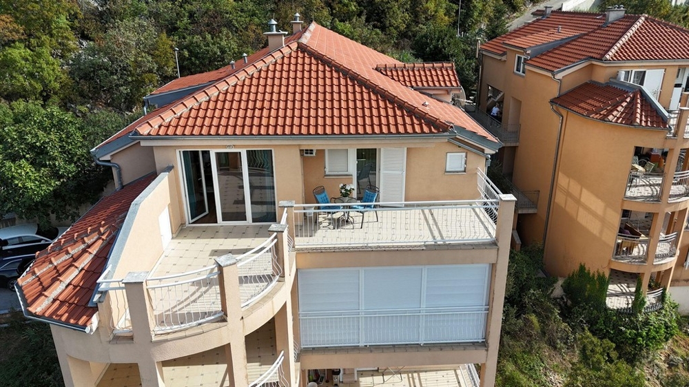 Vnější pohled na budovu s několika balkony a červenou taškovou střechou