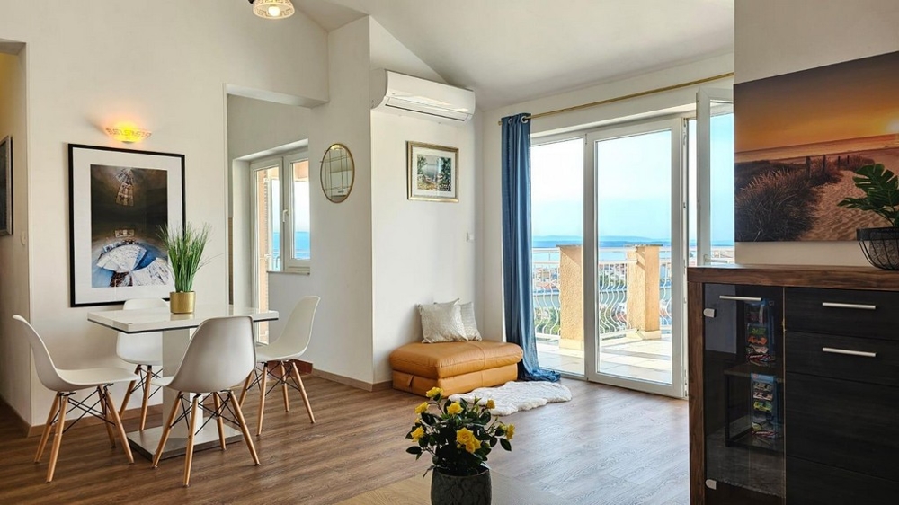 Obývací pokoj s velkým oknem a terasou