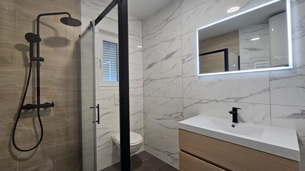 Moderní koupelna s dešťovou sprchou a zrcadlem