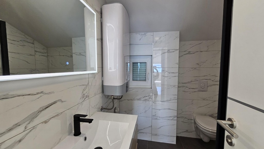 Koupelna se zrcadlem, umyvadlem a toaletou