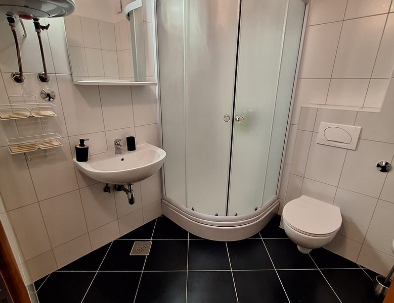 Moderní koupelna se sprchovým koutem, umyvadlem a toaletou