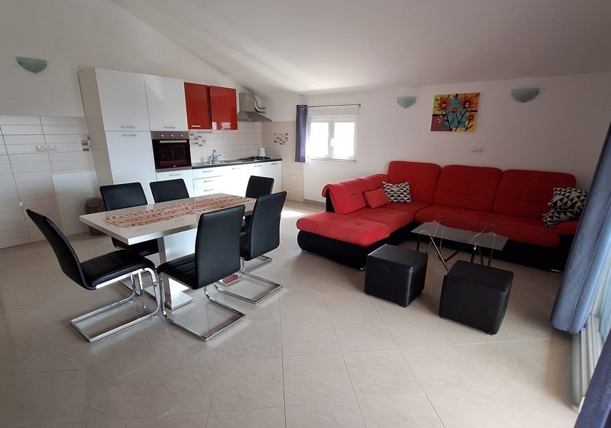 Jídelna s kuchyní a výhledem na pohovku bytu.