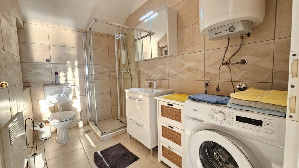 Udržovaná koupelna se sprchovým koutem.