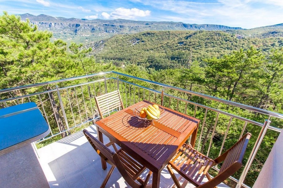 Pohled do zeleně z balkonu nemovitosti A3515 v Crikvenici v Chorvatsku.