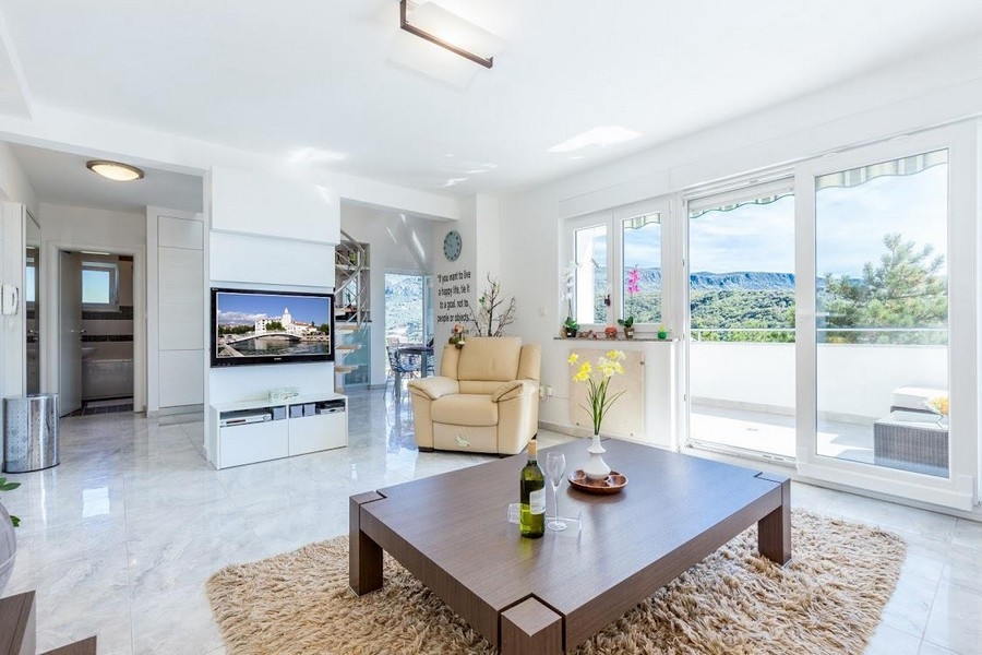 Obývací pokoj s velkým oknem a moderním nábytkem