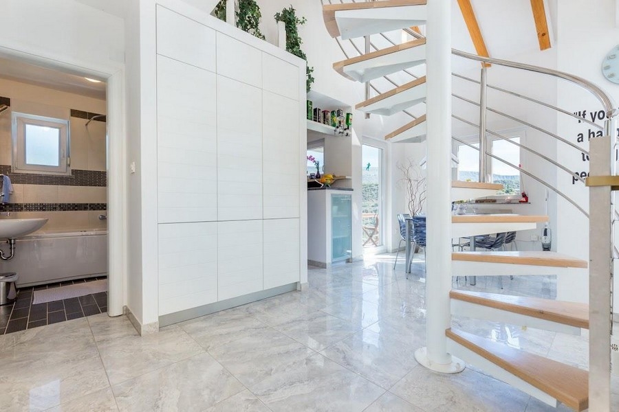 Dřevěné a kovové schodiště v otevřeném obývacím prostoru