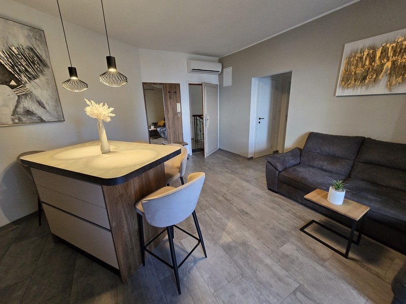 Útulný obývací pokoj s pohovkou, jídelním koutem a moderní kuchyní, klimatizovaný a zařízený