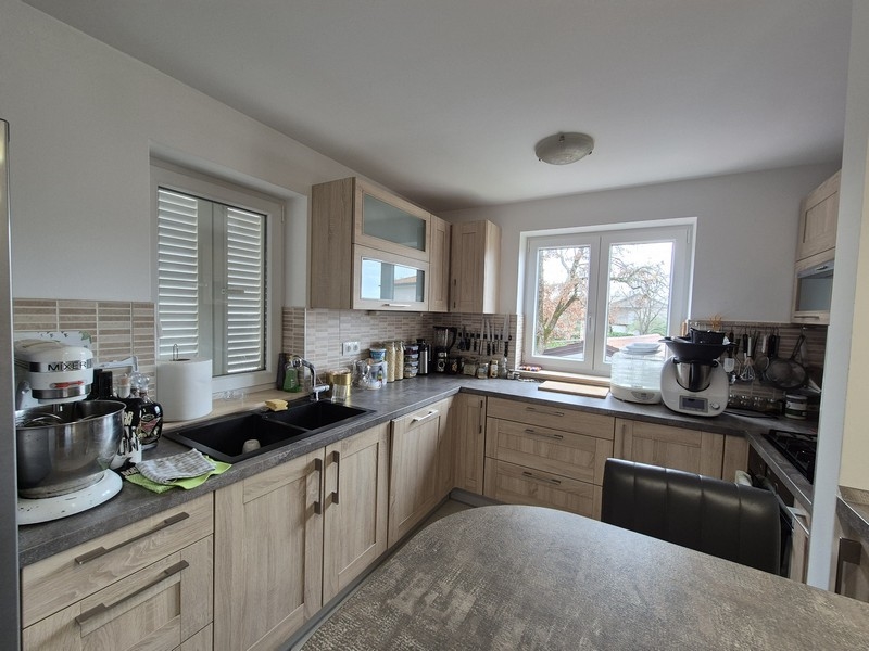 Moderní kuchyně s dřevěnými čely a výhledem ven