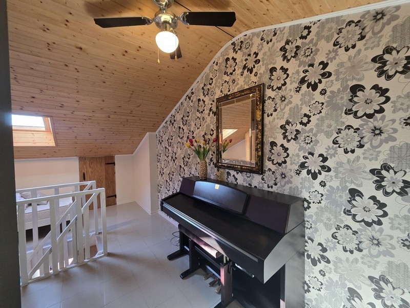 Horní patro s klavírem a šikmým stropem