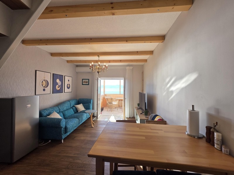 Obývací pokoj s pohovkou a výhledem na moře z balkonu