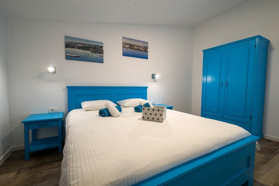 Ložnice s modrou postelí a šatní skříní